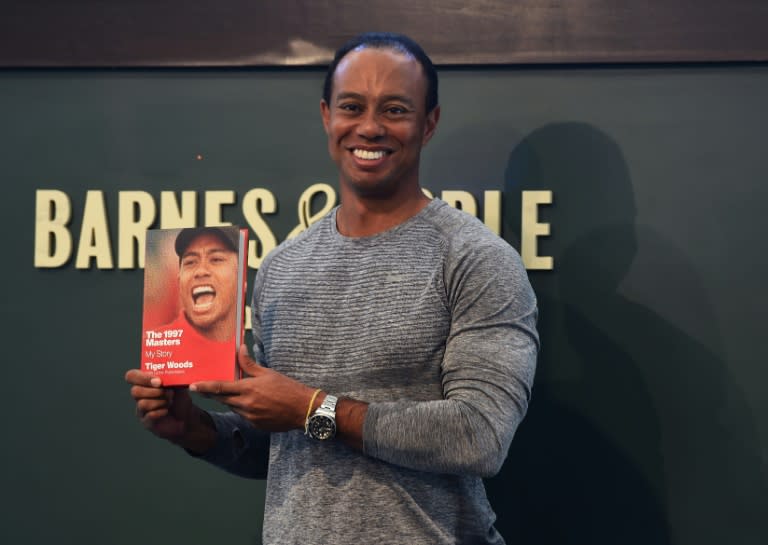 The 14-time major champ golfer Tiger Woods holds a copy of his new book "The 1997 Masters: My Story" at a book signing in New York