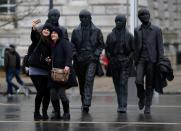 FILE PHOTO: Tourists pose for a selfie in front of a statue of The Beatles in Liverpool northern England