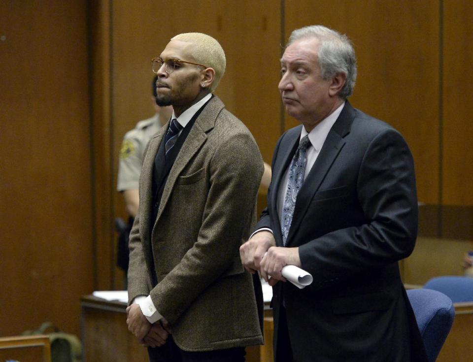 R&B singer Chris Brown, left, appears in court with his attorney Mark Geragos during a probation violation hearing in which his probation was revoked by a superior court judge on Monday, Dec. 16, 2013, in Los Angeles. Superior Court Judge James R. Brandlin revoked Brown's probation after his recent arrest on suspicion of misdemeanor assault in Washington, D.C., but the ruling will not alter the singer's requirements to complete rehab and community labor for his 2009 attack on Rihanna. (AP Photo/Kevork Djansezian, Pool)