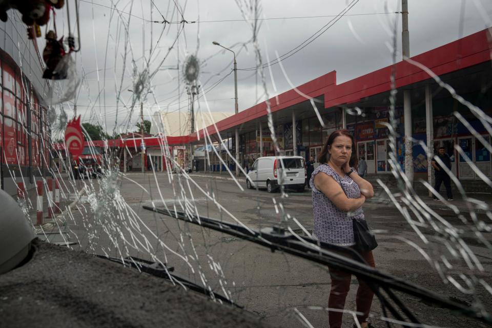 A woman looks at a trolleybus damaged by Russian shelling at Barabashovo market in Kharkiv, Ukraine, Thursday, July 21, 2022.