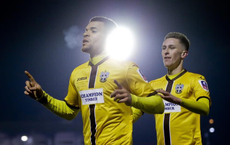 Sutton United's Maxime Biamou, left, celebrates after scoring his side's second goal of the game during the English FA Cup third round replay soccer match between AFC Wimbledon against Sutton United at Cherry Red Record stadium in south west London, Tuesday, Jan. 17, 2017 . (AP Photo/Alastair Grant)