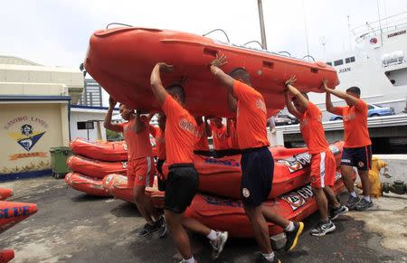 Members of the Philippine Coast Guard carry a rescue boat as they prepare for Typhoon Rammasun, locally name Glenda, in Manila July 15, 2014. REUTERS/Romeo Ranoco