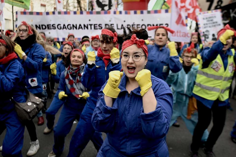 Who'll blink first: feminist activists dance at a Paris march against pension reforms: AFP via Getty Images