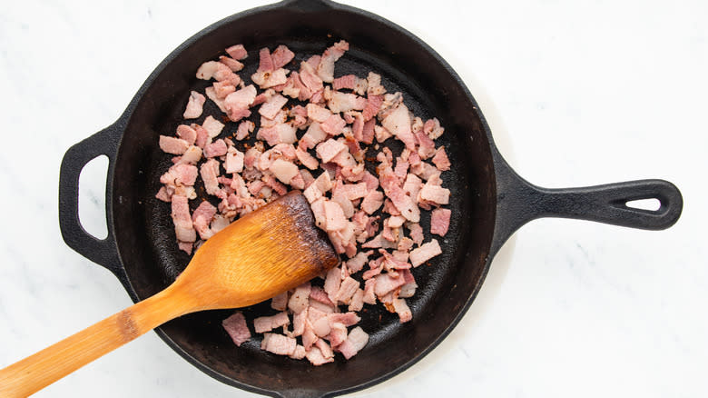 Chopped bacon frying in skillet
