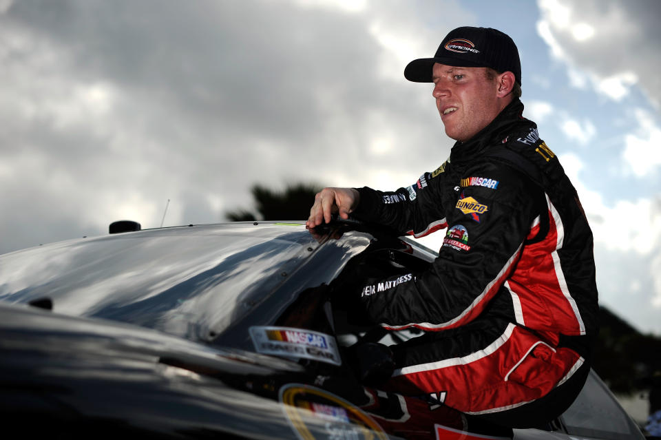 DAYTONA BEACH, FL - FEBRUARY 19: Regan Smith, driver of the #78 Furniture Row/CSX Chevrolet, climbs from his car after qualifying for the NASCAR Sprint Cup Series Daytona 500 at Daytona International Speedway on February 19, 2012 in Daytona Beach, Florida. (Photo by Jared C. Tilton/Getty Images for NASCAR)