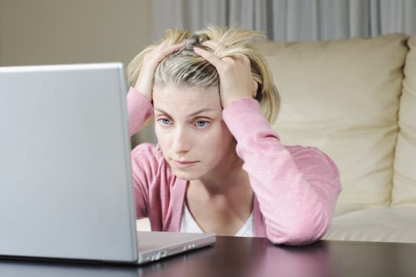 Photo of the frustrated woman unable to cope with problems on the computer. Horizontal framing with some barely visible vignette