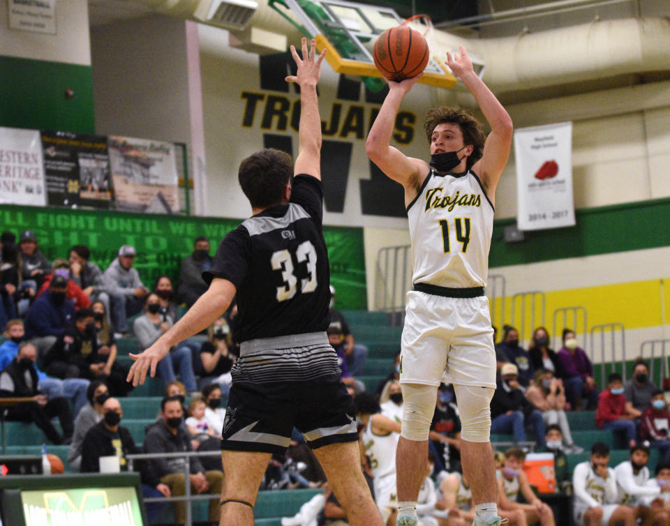 Mayfield's Cameron Sowards gets a 3-point shot off over Organ Mountain defender Brandon Kehres during the first half of their Friday night matchup.