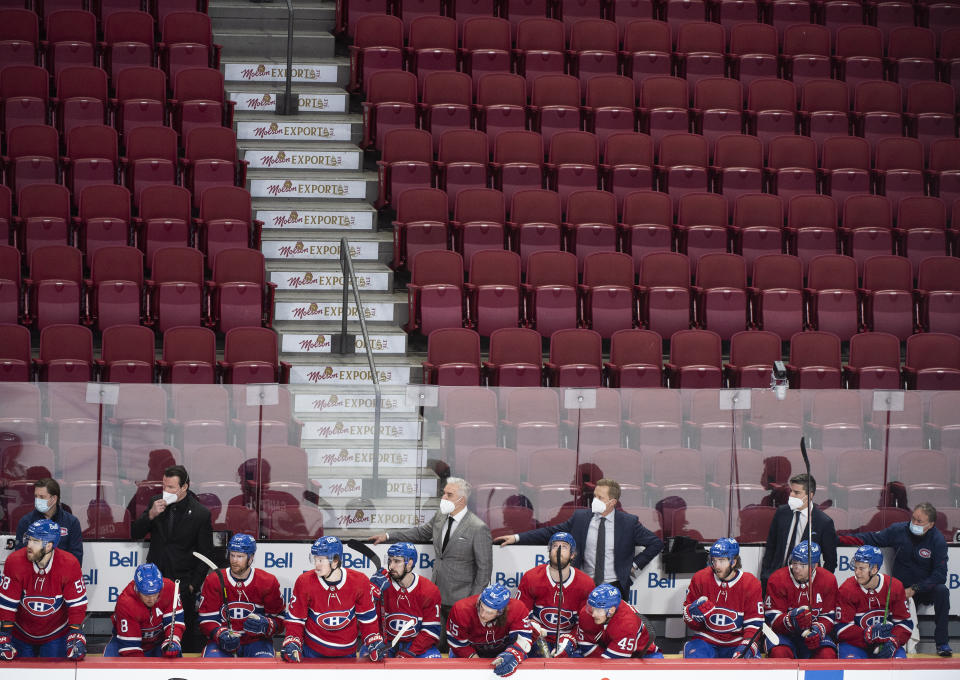Los jugadores y entrenadores de los Canadiens de Montreal miran desde el banquillo el encuentro frente a los Flyers de Filadelfia, disputado sin público el jueves 16 de diciembre de 2021 (Graham Hughes/The Canadian Press via AP)