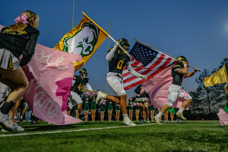 Rock Bridge's Grayson Crutchlow (0) and Spencer Irvin (4) lead the Bruins onto the field before a football game against Battle at Rock Bridge High School on Oct. 6, 2023, in Columbia, Mo.