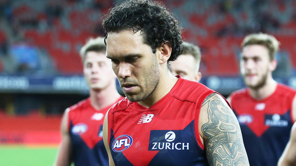 Demons player Harley Bennell (pictured middle) walking off the field looking dejected.