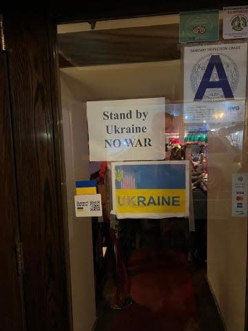 The front door of Russian Samovar, which says "stand by Ukraine," and "no war" along with a Ukrainian flag.