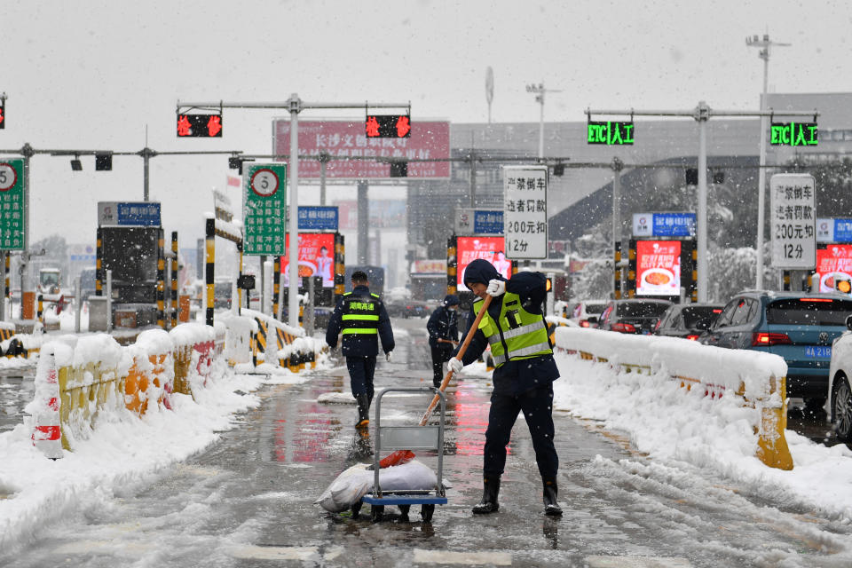 <strong>大陸正值春運高峰期，31日起將迎來大範圍雨雪冰凍天氣。圖為工作人員在湖南長沙的收費站拋撒融雪劑。（資料照／新華社）</strong>