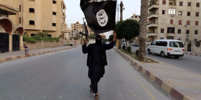 A member loyal to the Islamic State in Iraq and the Levant (ISIL) waves an ISIL flag in Raqqa June 29, 2014. The offshoot of al Qaeda which has captured swathes of territory in Iraq and Syria has declared itself an Islamic