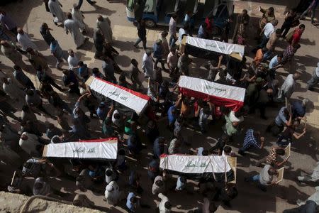 Mourners carry the coffins during the funeral of policemen, killed by a tank rigged with explosives, during a funeral in Najaf, south of Baghdad, June 2, 2015. REUTERS/Stringer