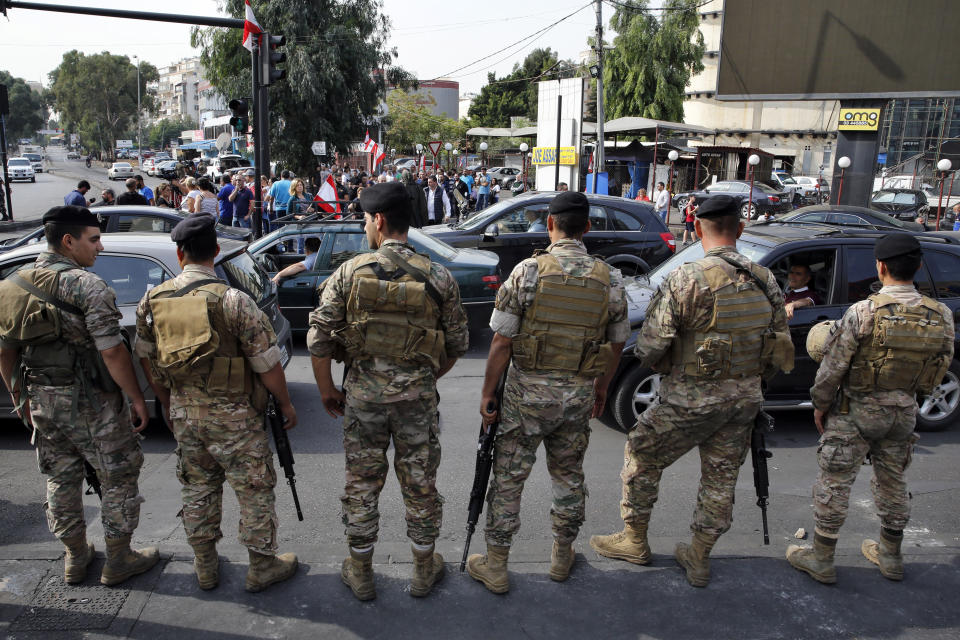 Lebanese soldiers stand guard after they unblock a road in Hazmiyeh, a suburb of Beirut, Lebanon, Saturday, Oct. 26, 2019. The removal of the roadblocks on Saturday comes on the tenth day of protests in which protesters have called for civil disobedience until the government steps down. (AP Photo/Bilal Hussein)