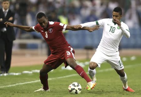 Saudi Arabia's Salem Al Dossary (R) fights for the ball with Qatar's Abdulkarim Hassan during their Gulf Cup final soccer match in Riyadh November 26, 2014. REUTERS/Fadi Al-Assaad