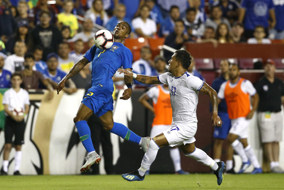 Brazil forward Douglas Costa, left, tries to maintain possession as he is pressured by El Salvador defender Juan Barahona in the first half of a soccer match, Tuesday, Sept. 11, 2018, in Landover, Md. (AP Photo/Patrick Semansky)