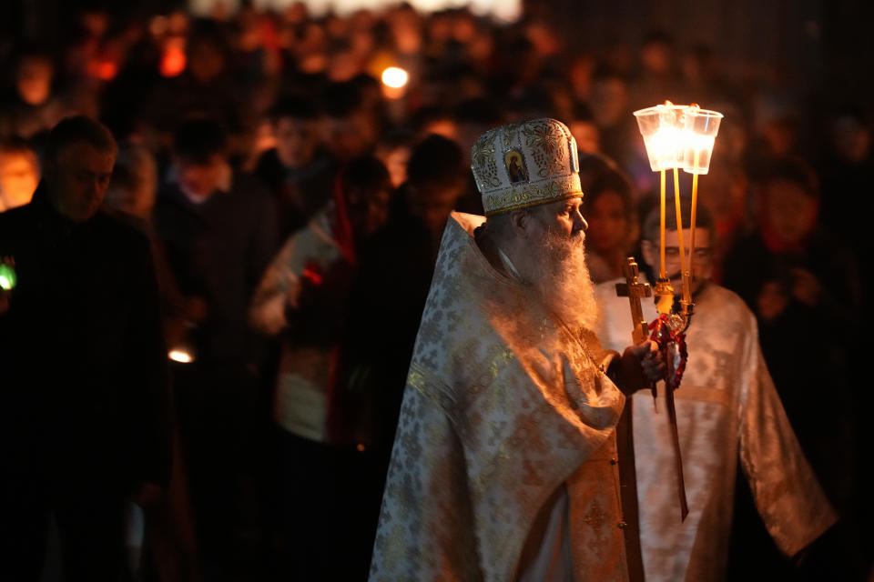 Orthodox pries and believers walk with candles around a church during Orthodox Easter midnight service in St. Petersburg, Russia, Sunday, May 5, 2024. Eastern Orthodox churches observe the ancient Julian calendar and this year celebrate Orthodox Easter on May 5. (AP Photo/Dmitri Lovetsky)