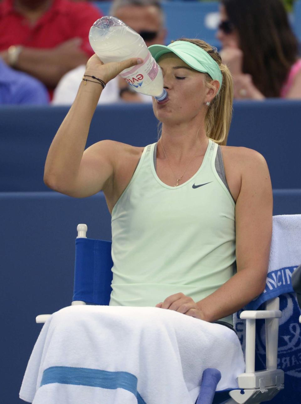 Maria Sharapova, from Russia, drinks from a water bottle during a match against Sloane Stephens, from the United States, at the Western & Southern Open tennis tournament, Tuesday, August 13, 2013, in Mason, Ohio. (AP Photo/Michael E. Keating)