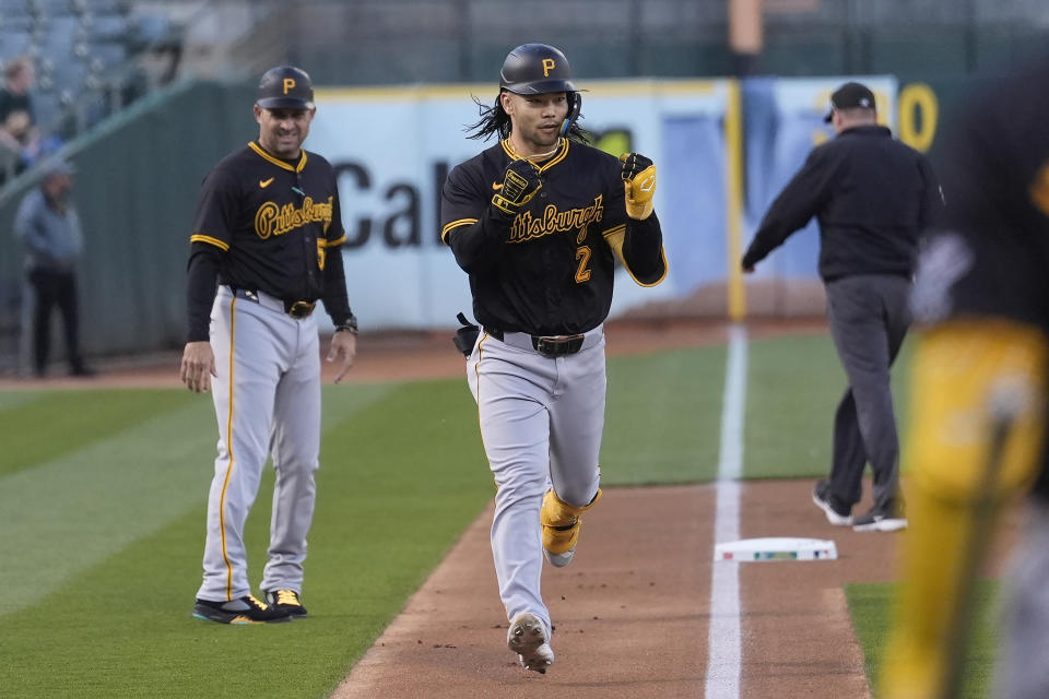 Pittsburgh Pirates' Connor Joe (2) gestures toward teammates past third base coach Mike Rabelo, left, after hitting a home run during the first inning of a baseball game against the Oakland Athletics in Oakland, Calif., Tuesday, April 30, 2024. (AP Photo/Jeff Chiu)