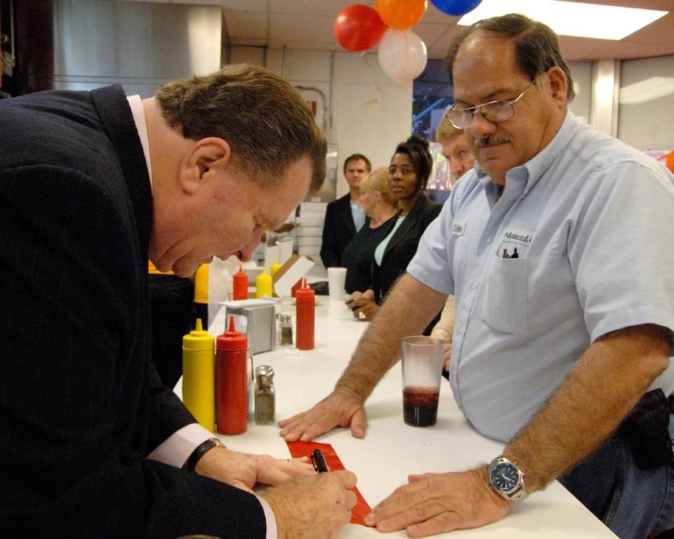 In 2009, Wayne Arnold, owner of a late-surviving Royal Castle in North Miami, signs a piece of the ribbon used in the grand reopening of his restaurant for patron Juan Criscuolo, a regular customer for more than 25. Criscuolo said he remembers his first time sitting at the counter as a young boy in the late 1960s.