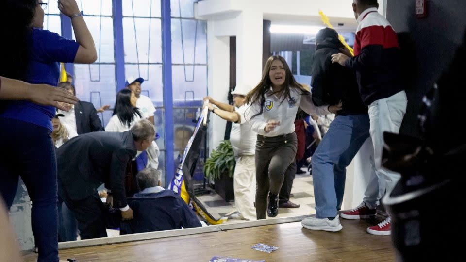 People take cover after shots were fired at the end of a rally of Ecuadorian presidential cadidate Fernando Villavicencio in Quito on August 9. - AFP/Getty Images