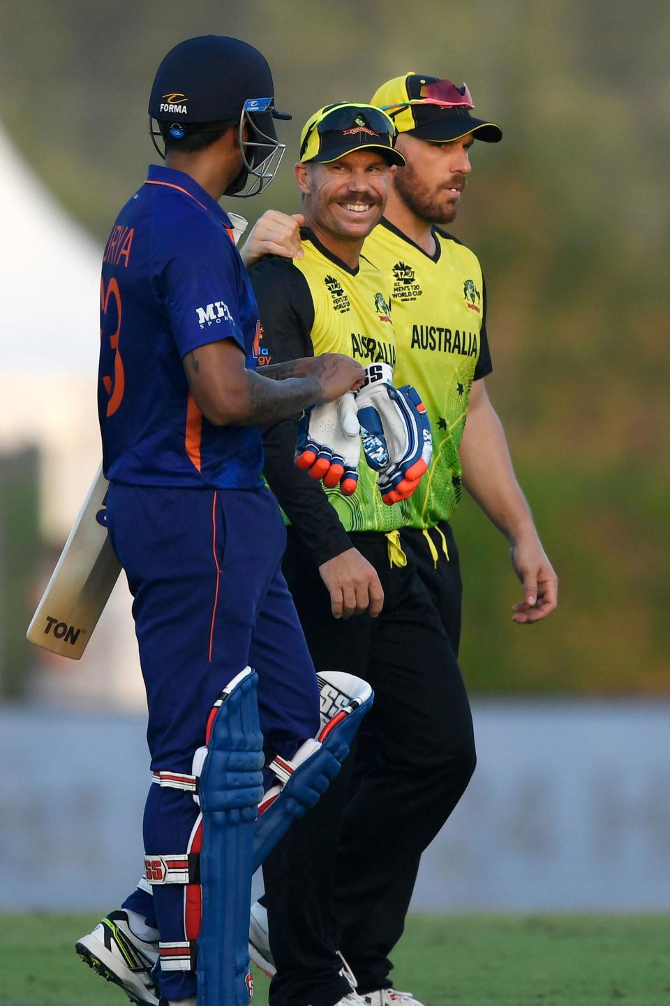 Suryakumar Yadav (pictured left) speaks with David Warner (pictured middle) at the end of a warmup cricket match between India and Australia for the ICC mens Twenty20 World Cup.