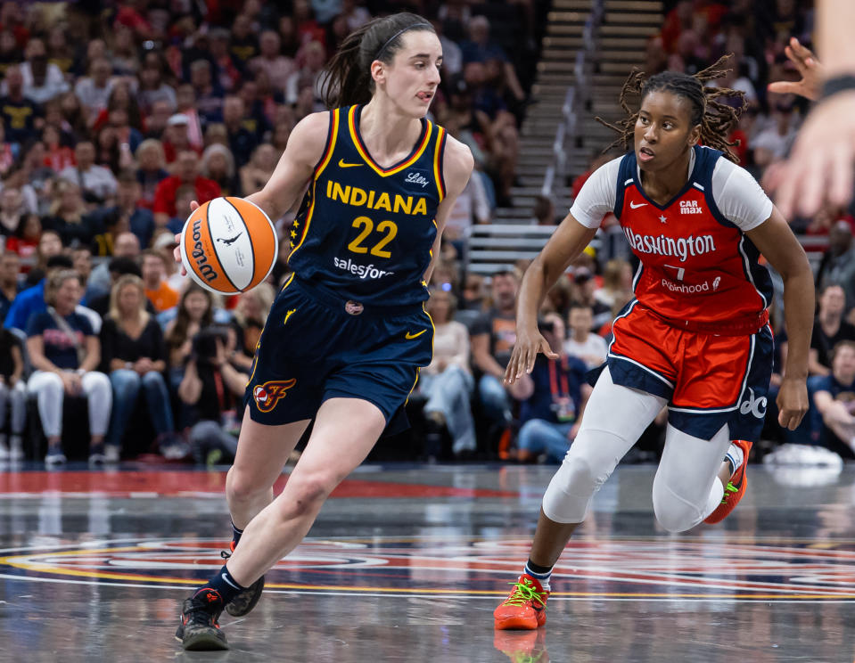 INDIANAPOLIS, INDIANA - JULY 10: Caitlin Clark #22 of the Indiana Fever dribbles against Ariel Atkins #7 of the Washington Mystics at Gainbridge Fieldhouse on July 10, 2024 in Indianapolis, Indiana. NOTE TO USER: User expressly acknowledges and agrees that by downloading and/or using this photo, User agrees to the terms and conditions of the Getty Images License Agreement. (Photo by Michael Hickey/Getty Images)