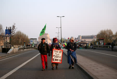 Climate change activists walk along Waterloo Bridge during a blockage during the Extinction Rebellion protest in London, Britain April 17, 2019. REUTERS/Hannah McKay