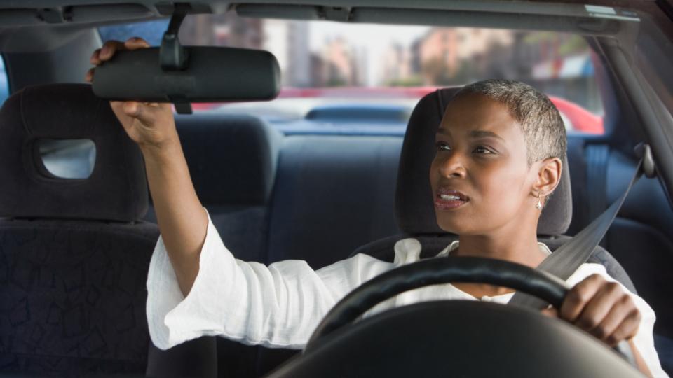  Woman driver adjusted her car mirror. 