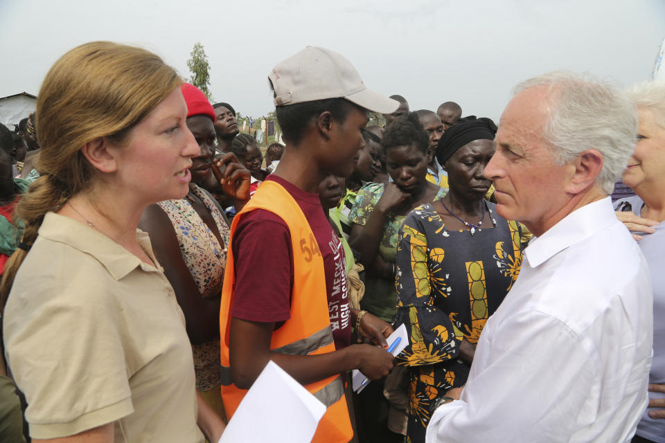 In this photo taken on Friday April 14, 2017, U.S Senator Bob Corker, right, speaks with an official from the World Food Program at the Bidi Bidi refugee settlement in Uganda. In a political climate dominated by President Donald Trump's slogan of "America First," two U.S. senators are proposing making American food aid more efficient after meeting with victims of South Sudan's famine and civil war. After visiting the world's largest refugee settlement in northern Uganda, Democratic Sen. Chris Coons of Delaware told The Associated Press that the U.S. "can deliver more food aid at less cost" through foreign food aid reform. (AP/Photo/Justin Lynch)