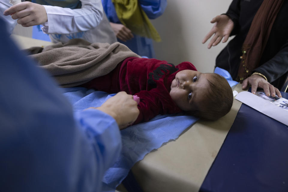 A baby on an exam table at the hospital.