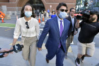 Former Fall River, Mass. Mayor Jasiel Correia and his wife Jenny Fernandes, left, leave a court appearance at the John Joseph Moakley United States Courthouse, Monday, Sept. 20, 2021, in Boston. A federal judge said he planned to toss several convictions against the Massachusetts mayor elected at just 23 years old who was found guilty by jurors of bilking investors and extorting hundreds of thousands of dollars from marijuana businesses. (AP Photo/Josh Reynolds)