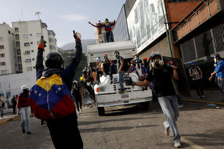 Demonstrators stand on a truck they want to use as a barricade while clashing with riot security forces during a rally against Venezuela's President Nicolas Maduro in Caracas, Venezuela, May 31, 2017. REUTERS/Carlos Garcia Rawlins