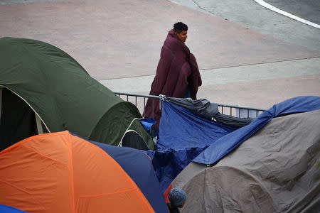 A man traveling with a caravan of migrants from Central America walks at a camp near the San Ysidro checkpoint, after 49 Central Americans crossed into the United States to seek asylum on Wednesday, in Tijuana, Mexico May 2, 2018. REUTERS/Edgard Garrido