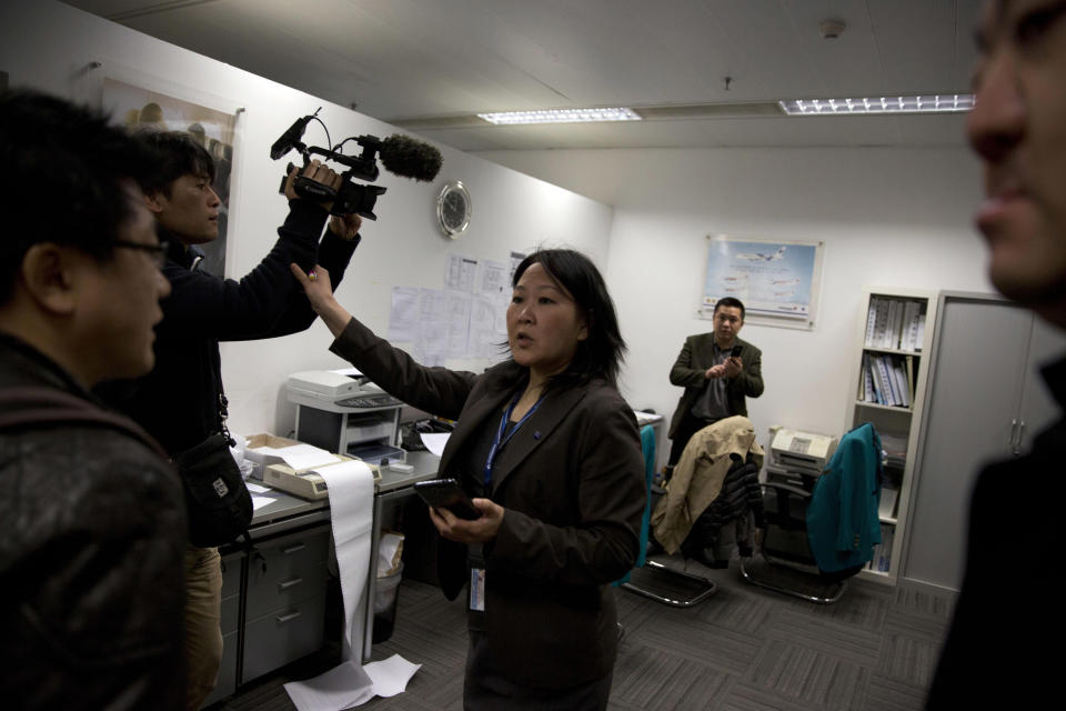 Una mujer que trabaja en las oficinas de "Malaysian Airlines" en Beijing, China, reacciona ante la llegada de los periodistas este 8 de marzo de 2014. AP Photo/Ng Han Guan