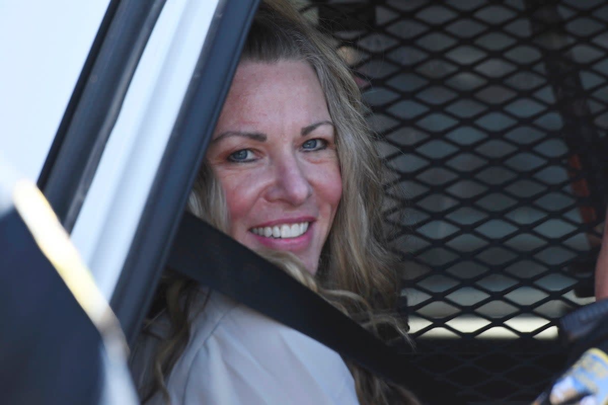Lori Vallow smiles in the back of a police car as she leaves a court hearing for her children’s murders in August 2022  (AP)