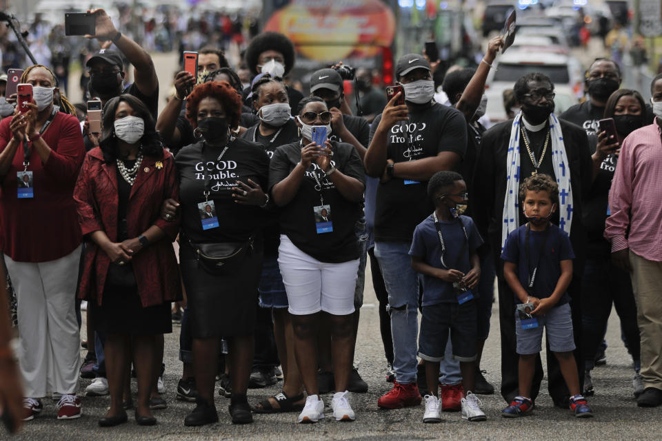 Mourners watch the casket of Rep. John Lewis move over the Edmund Pettus Bridge by horse drawn carriage during a memorial service for Lewis, Sunday, July 26, 2020, in Selma, Ala. Lewis, who carried the struggle against racial discrimination from Southern battlegrounds of the 1960s to the halls of Congress, died Friday, July 17, 2020. (AP Photo/Brynn Anderson)