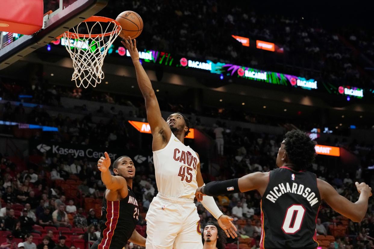 Cleveland Cavaliers guard Donovan Mitchell (45) drives to the basket over Miami Heat center Orlando Robinson (25) during the first half of an NBA basketball game, Friday, Dec. 8, 2023, in Miami. (AP Photo/Marta Lavandier)