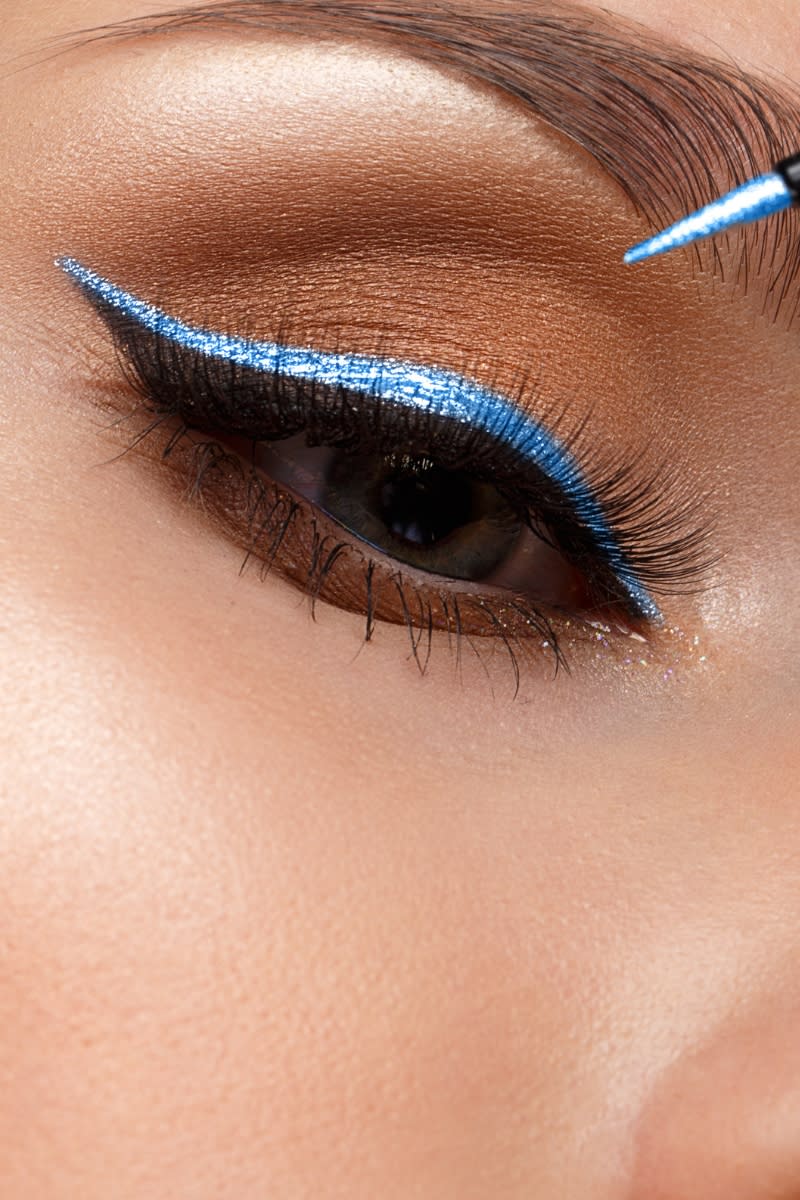 An eye with a blue and black double eyeliner