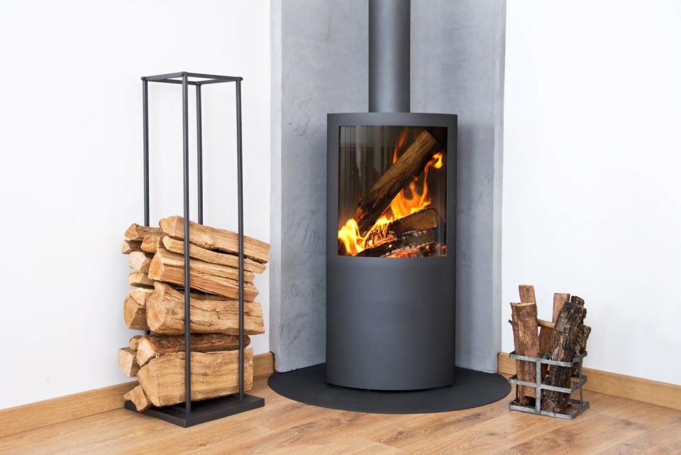 modern burning stove next to a wood logs rack