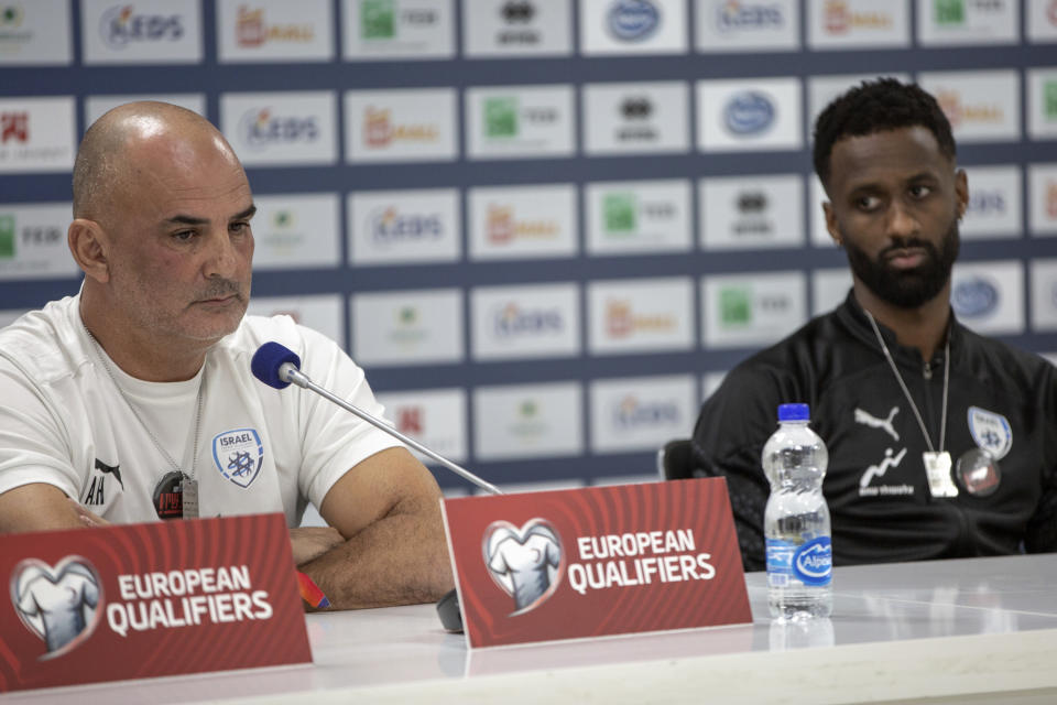 Israeli head coach Alon Hazan, left, joined by team captain Eli Dasa, take part in a press conference before the training session for the Euro 2024 group I qualifying soccer match between Kosovo and Israel at the Fadil Vokrri stadium in Pristina, Kosovo, Saturday, Nov. 11, 2023. (AP Photo/Visar Kryeziu)