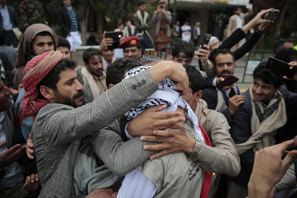 A Houthi prisoner hugs relatives as he arrives to Sanaa airport, Saturday, April 15, 2023. An exchange of more than 800 prisoners linked to Yemen's long-running war them began Friday, the International Committee for the Red Cross said. The three-day operations will see flights transport prisoners between Saudi Arabia and Yemen's capital, Sanaa, long held by the Iranian-backed Houthi rebels. ((AP Photo/Hani Mohammed)