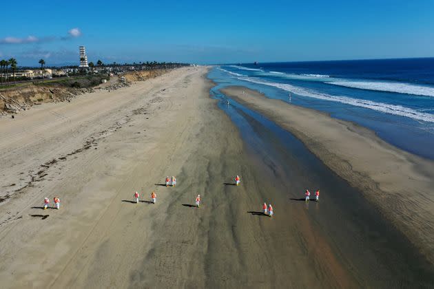 Environmental cleanup crews pick oil chucks off Huntington Dog Beach in Huntington Beach, California. (Photo: Allen J. Schaben/Los Angeles Times via Getty Images)