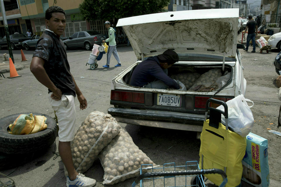 Un hombre carga su automóvil con papas compradas en Colombia, en San Antonio del Táchira, Venezuela, en la frontera con Colombia, el jueves 21 de febrero de 2019. (AP Foto / Rodrigo Abd)