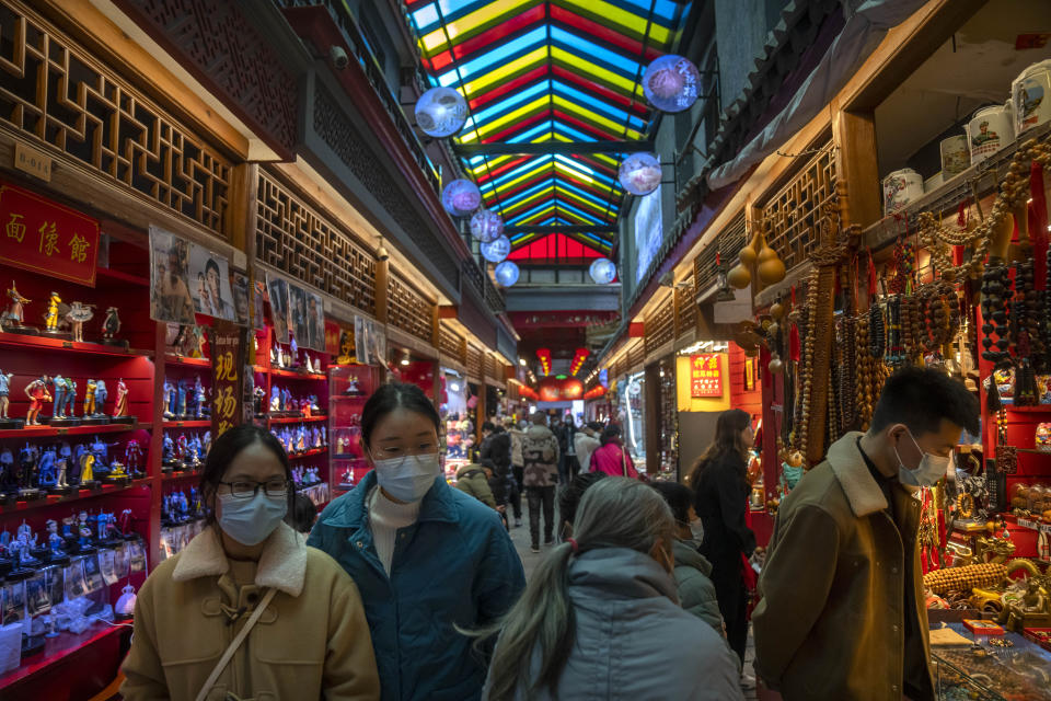 FILE - Visitors look at shops selling trinkets and souvenirs along a tourist shopping street in Beijing, Feb. 28, 2023. China’s recovery from the pandemic and strong demand in India will drive strong growth in Asia this year, the Asian Development Bank said in a report issued Tuesday, April 4. (AP Photo/Mark Schiefelbein, File)