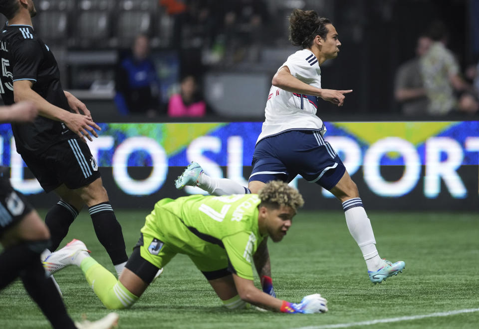 Vancouver Whitecaps' Simon Becher, back right, celebrates his goal against Minnesota United goalkeeper Dayne St. Clair during the second half of an MLS soccer match in Vancouver, British Columbia., Saturday, May 6, 2023. (Darryl Dyck/The Canadian Press via AP)