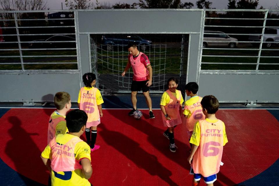 St. Louis City SC defender Kyle Hiebert (22) plays soccer with half a dozen children on Thursday, Oct. 26, 2023, during the dedication of a community mini pitch at Granby Park in Fairmont City. Brian Munoz/Brian Munoz