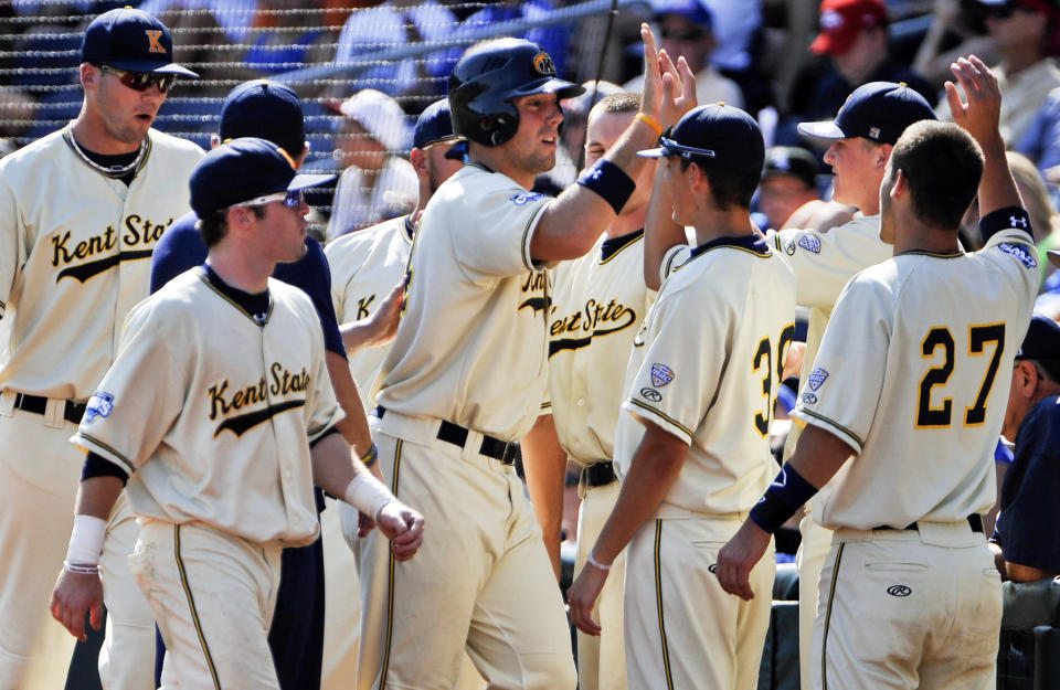 Kent State's Jason Bagoly, center, is congratulated by teammates after he scored against Florida on a single by Jimmy Rider in the second inning of an NCAA College World Series elimination baseball game in Omaha, Neb., Monday, June 18, 2012. (AP Photo/Eric Francis)