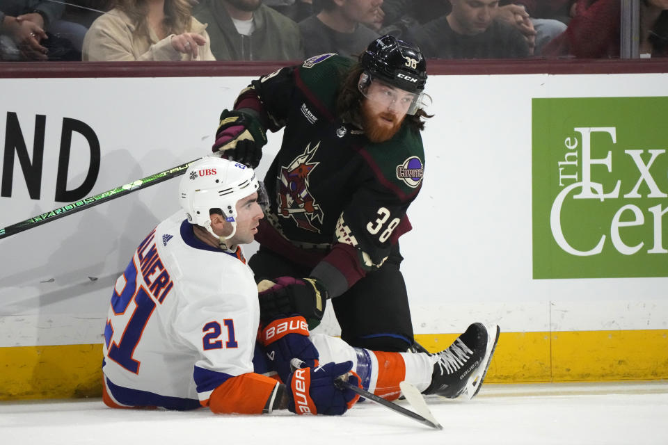 Arizona Coyotes center Liam O'Brien (38) collides with New York Islanders center Kyle Palmieri (21) during the first period of an NHL hockey game Thursday, Jan. 4, 2024, in Tempe, Ariz. (AP Photo/Ross D. Franklin)